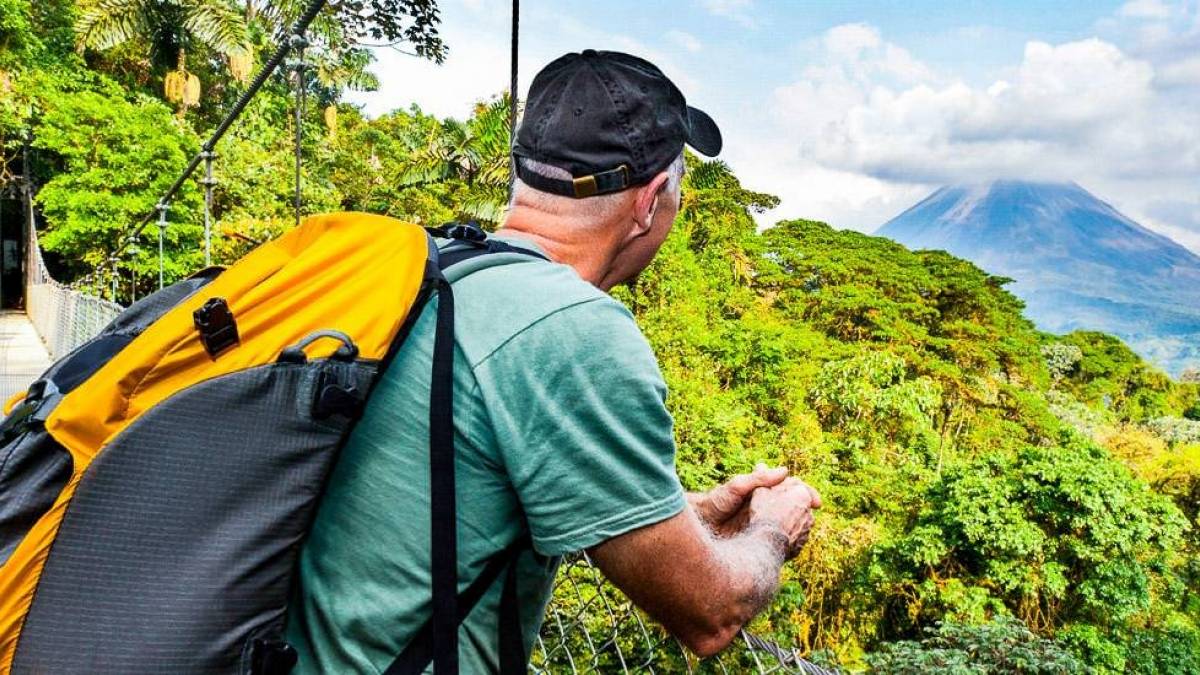 Blick über die Baumwipfel auf den Vulkan Arenal | © Pierre Chouinard, iStockphoto.com / Chamäleon Blick über die Baumwipfel auf den Vulkan Arenal | © Pierre Chouinard, iStockphoto.com / Chamäleon